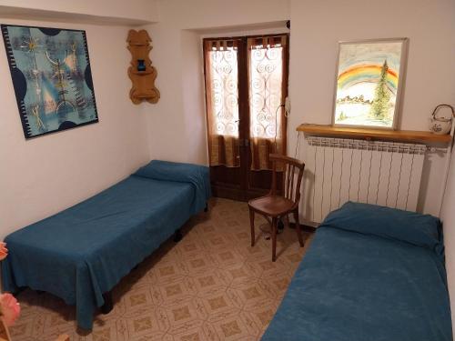 コーリコにあるCasa Letiziaのベッド2台、椅子、窓が備わる客室です。