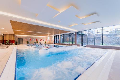 a pool in a building with clouds in the water at DCS Polana Jakuszycka in Szklarska Poręba