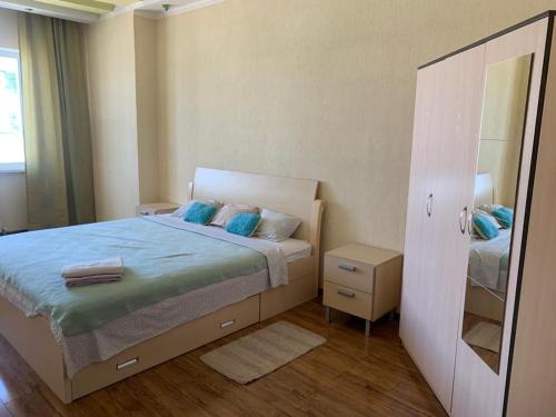 Dormitorio pequeño con cama y espejo en Комфортабельная комната в квартире en Astaná