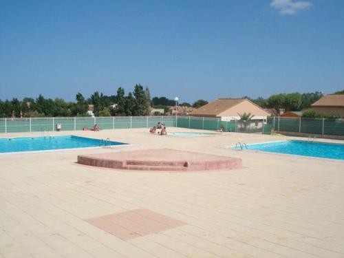 une piscine vide avec deux piscines et deux dans l'établissement Pavillon 3 Pièces avec Jardinet, Terrasse, et Piscine - 4 Personnes, Vendres - FR-1-701-26, à Vendres