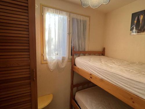 sypialnia z dwoma łóżkami piętrowymi i oknem w obiekcie Pavillon 3 Pièces avec Jardinet, Terrasse, et Piscine - 4 Personnes, Vendres - FR-1-701-26 w mieście Vendres