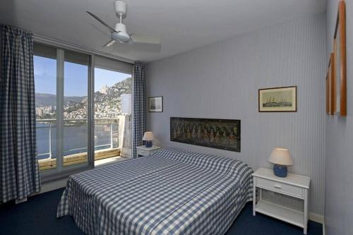 une chambre avec un lit et une grande fenêtre dans l'établissement Grand bleu, appartamento vista mare e Monaco, à Roquebrune-Cap-Martin