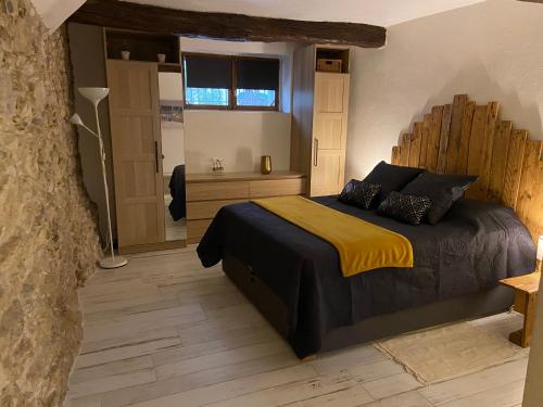 Appartement dans quartier historique de Mouans-Sartoux في موانس سارتوكس: غرفة نوم بسرير كبير مع بطانية صفراء