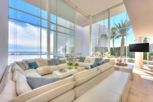 a living room with a large couch and large windows at Viceroy Los Cabos in San José del Cabo