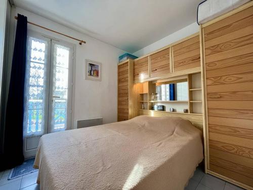 une chambre avec un lit et une grande fenêtre dans l'établissement Appartement 2 pièces à 400m de la plage avec balcon et parking - Saint-Georges-d'Oléron - FR-1-246A-189, à Saint-Georges-dʼOléron