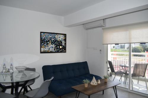 a living room with a blue couch and a table at Maria Holiday Apartments in Protaras