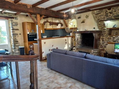 a living room with a couch and a fireplace at Maison au pied du Mont Saint Michel 2 in Pontorson