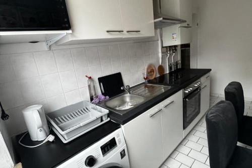 uma cozinha com um lavatório e uma bancada em Private Rooms em Hanôver