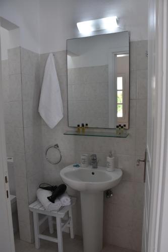 a bathroom with a sink and a mirror at Spacious veranda, house for 3, in the village. in Kamari