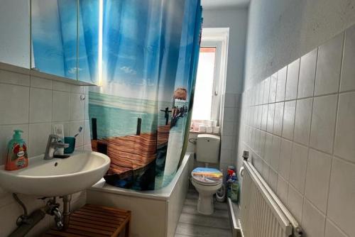 uma casa de banho com um lavatório e um WC com uma cortina de chuveiro em Private Rooms em Hanôver