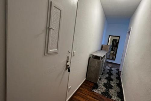 um corredor com uma porta branca e um estojo de escadas em Private Rooms em Hanôver
