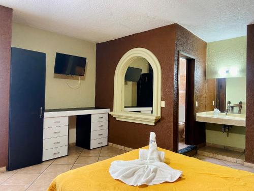 a bedroom with a bed and a sink and a mirror at Hotel Cabañas Santa Cruz in Oaxtepec