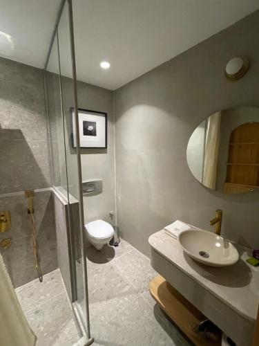 y baño con ducha, lavabo y aseo. en Monk Hotel Alaçatı, en Alacati
