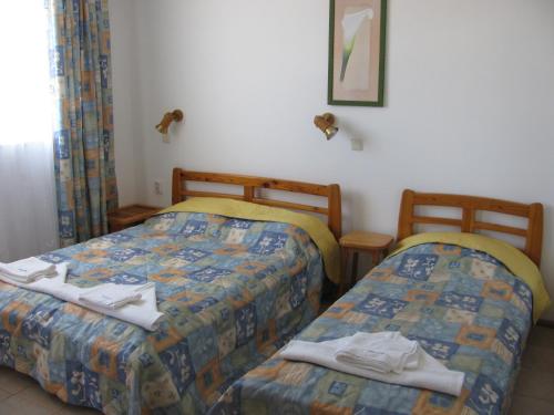 two beds in a hotel room with towels on them at Villa Sens in Chernomorets