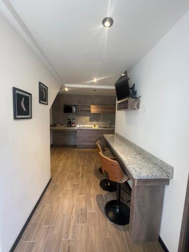 uma cozinha com um balcão, uma mesa e cadeiras em SOLSTICIO 212 em Cholula