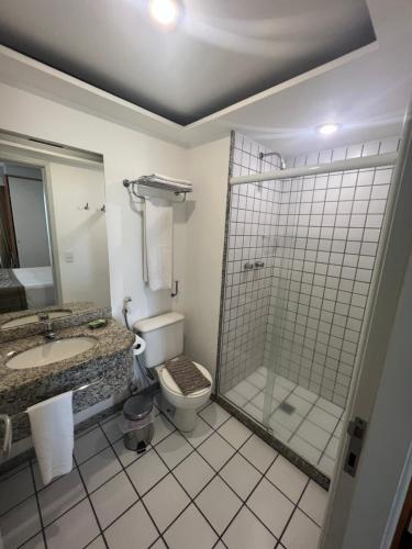 a bathroom with a shower and a toilet and a sink at Praia do Canto Apart Hotel Frente Mar in Vitória