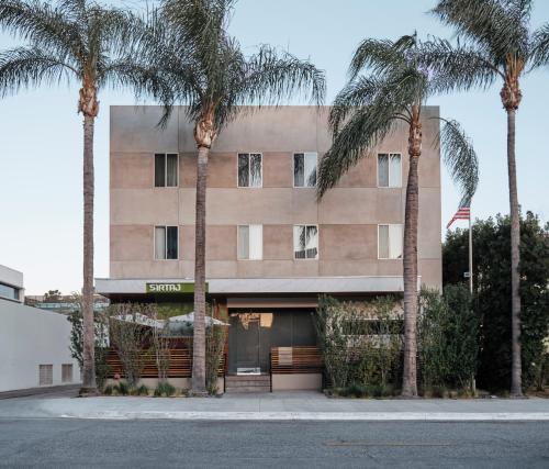 un bâtiment avec des palmiers en face de celui-ci dans l'établissement SIRTAJ – Beverly Hills, à Los Angeles