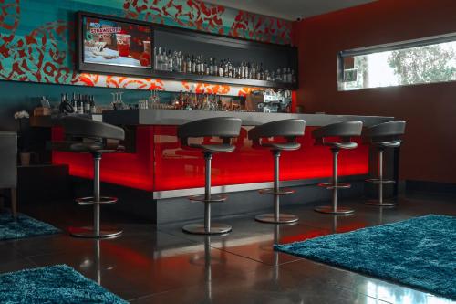 a bar with black stools and a red counter at SIRTAJ – Beverly Hills in Los Angeles