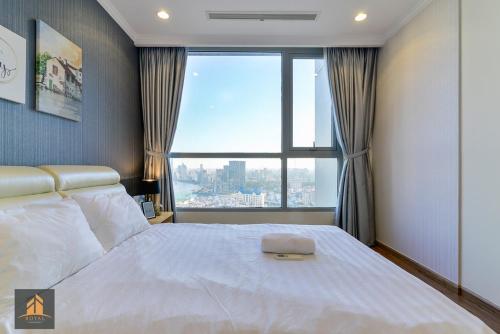 ein Schlafzimmer mit einem großen Bett und einem großen Fenster in der Unterkunft Vinhomes Landmark 81 in Ho-Chi-Minh-Stadt