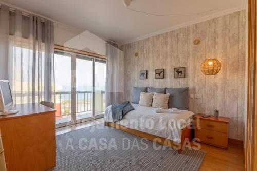 a bedroom with a bed and a large window at Villa du Soleil by ACasaDasCasas in Ericeira