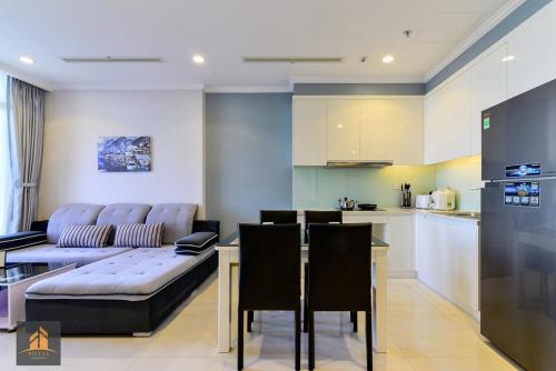 eine Küche und ein Wohnzimmer mit einem Sofa und einem Tisch in der Unterkunft Vinhomes Landmark 81 in Ho-Chi-Minh-Stadt