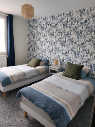 2 Betten in einem Schlafzimmer mit Tapete in der Unterkunft Natif 4 personnes in Aire-sur-la-Lys