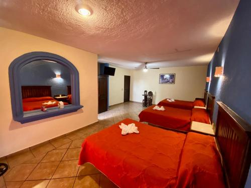 a hotel room with two beds and a window at Hotel Cabañas Santa Cruz in Oaxtepec