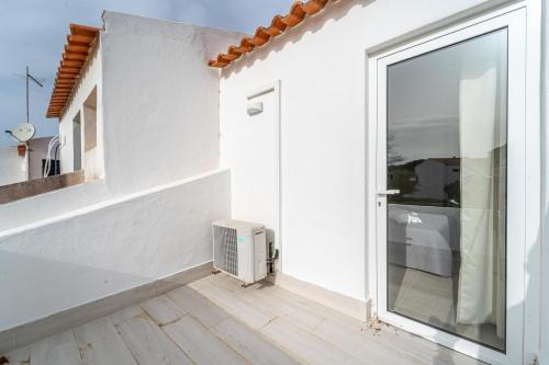 biały pokój z oknem i grzejnikiem w obiekcie Villa Alfamar by HelloVacations w Albufeirze