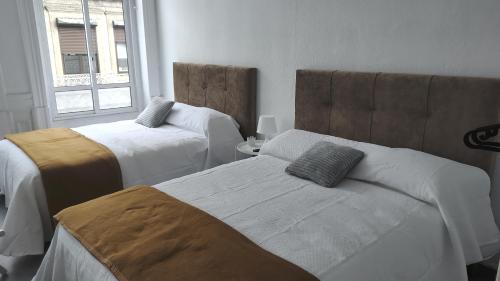 Cette chambre comprend 2 lits et une fenêtre. dans l'établissement Guesthouse Franco, à Porto