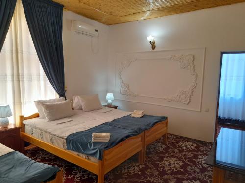 a bedroom with a bed and a window at Boutique Hotel Parvina in Bukhara
