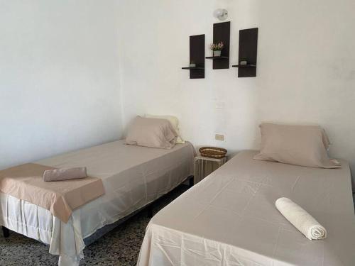 - deux lits assis l'un à côté de l'autre dans une pièce dans l'établissement Habitación Privada en Flores, à Flores
