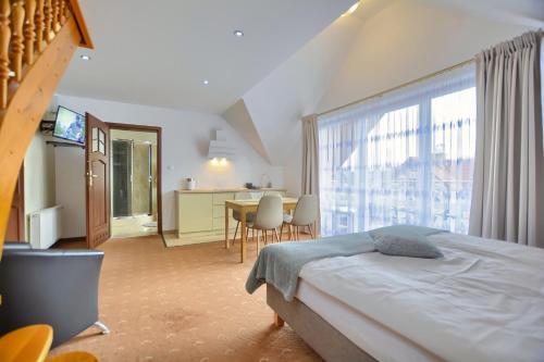 a bedroom with a bed and a large window at Willa Teresa in Karpacz