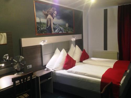 a hotel room with a bed with red and white pillows at Rheinhotel Lilie in Boppard
