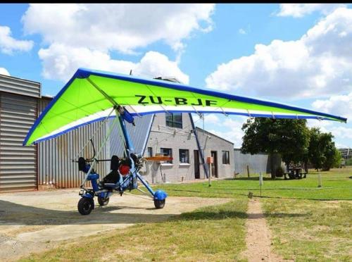 Philadelphia的住宿－Cape Sky Adventures，停在田野上的蓝色和绿色滑翔机