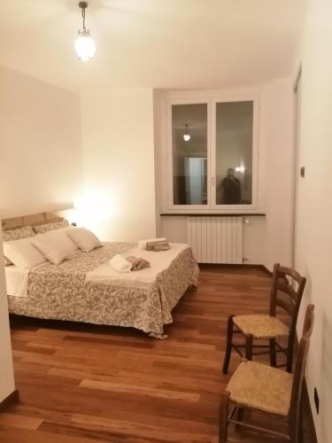a bedroom with two beds and a window and a chair at Affittacamere Armanino in Genova