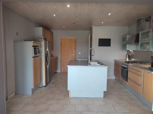 a kitchen with a white island in the middle at Le Floyon (avec piscine) in Florennes