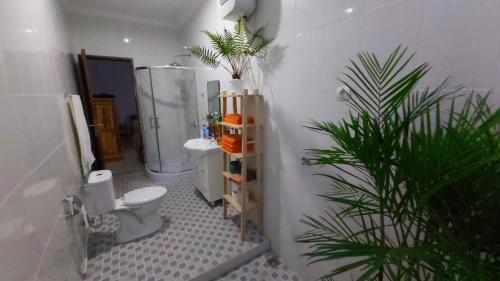 baño con aseo, ducha y planta en VILLA PAPA PUTU, en Banjar
