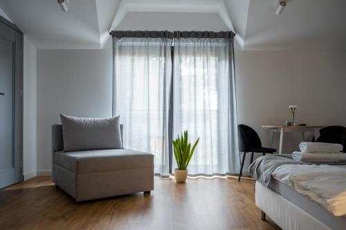 a bedroom with a bed and a chair and a window at Przy3Maja in Legionowo