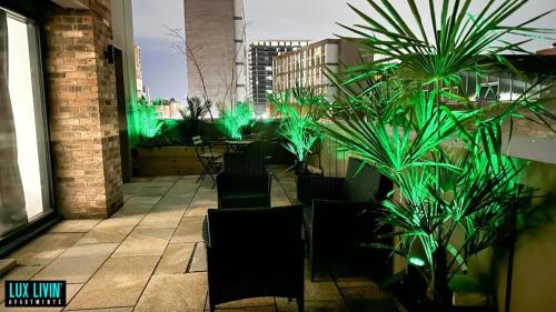 a patio with chairs and plants with green lights at Lux Livin' Apartments - Luxury 2 Bed Apartment with Sky Garden in Manchester