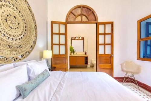 une chambre avec un grand lit blanc et un miroir dans l'établissement 2CM-J1 APARTAMENTO DE 2 ALCOBAS CON VISTA Y PISCINA EN GETSEMANI, à Carthagène des Indes