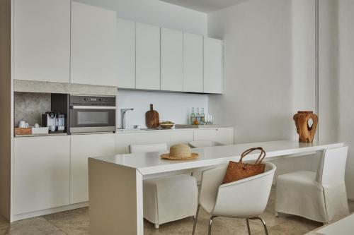 a kitchen with white cabinets and a table and chairs at Viceroy Los Cabos in San José del Cabo