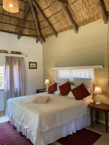 una camera da letto con letto, lenzuola e cuscini bianchi di Waterberg Cottages, Private Game Reserve a Vaalwater
