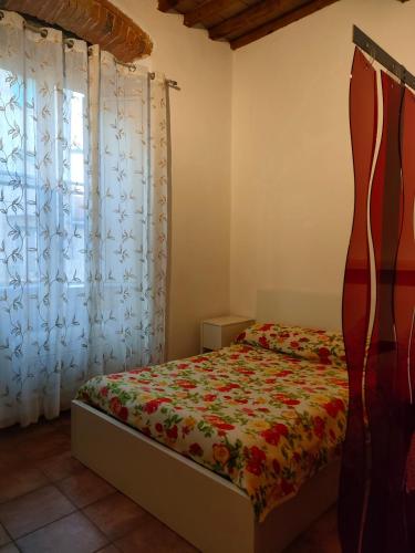 1 dormitorio con cama y ventana en Mini appartamento, en Livorno