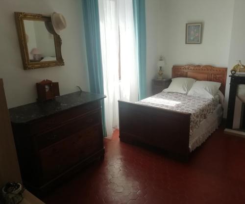 a bedroom with a bed and a dresser and a mirror at Chez Fleur in Avignon