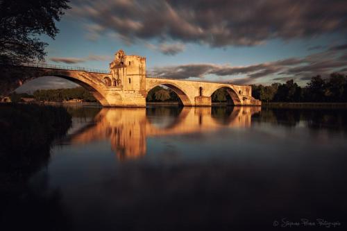 a bridge over a body of water with a building at Chez Fleur in Avignon