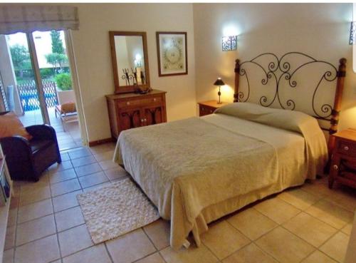 um quarto com uma cama, uma cadeira e um espelho em Citadela I, Golfe, Pool and Falesia Beach em Vilamoura