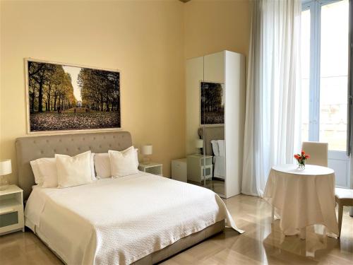 1 dormitorio con cama blanca y mesa en Armonia B&B, en Lecce