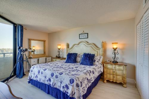 ein Schlafzimmer mit einem Bett mit blauen Kissen in der Unterkunft Cozy Condo with Gulf View, Bird Watching and Telescope in Hudson