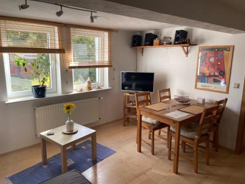 comedor con mesa, sillas y TV en Ferienwohnung am Brunnenplatz, en Bad Sooden-Allendorf