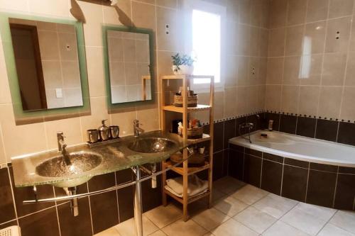 une salle de bain avec deux lavabos et une baignoire dans l'établissement Istres villa spacieuse , vue imprenable, à Istres
